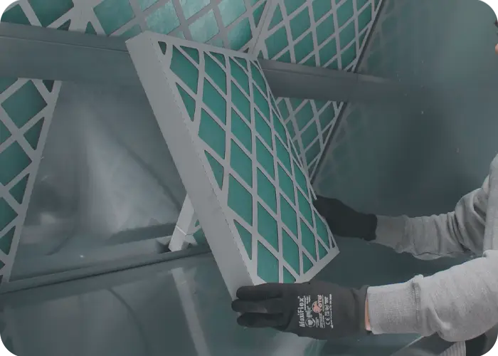 Pourquoi, comment et quand changer ses filtres de cabine de peinture - opérateur qui remplace les filtres