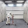 peintre en action dans une cabine de peinture rétractable