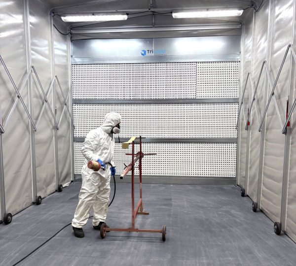peintre en action dans une cabine de peinture rétractable