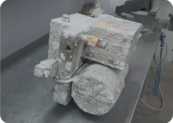 Un moteur encrassé prêt à être nettoyé et décapé avec une table aspirante et captation des poussières