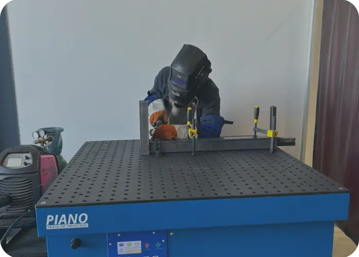 Un opérateur utilise une table aspirante Piano pour soudure, acquise grâce aux subventions CARSAT